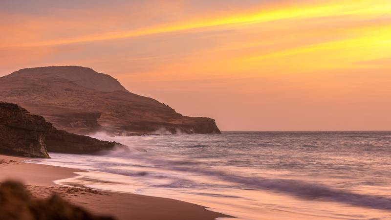 Roter Sandstrand in Kolumbien, der die Wellen gleichsam rot f&auml;rbt bei Sonnenuntergang