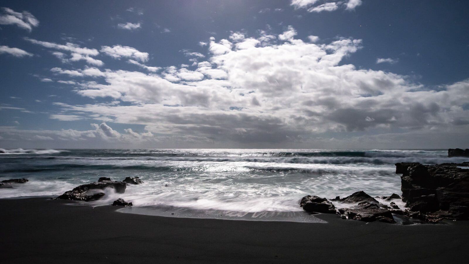 Vollmondnacht am schwarzen Strand von Lanzarote mit silberfarbener Lichtstimmung