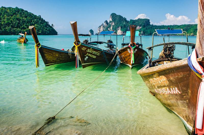 Fischerboote im Vordergrund, am bekannten Strand von Phi Phi Island